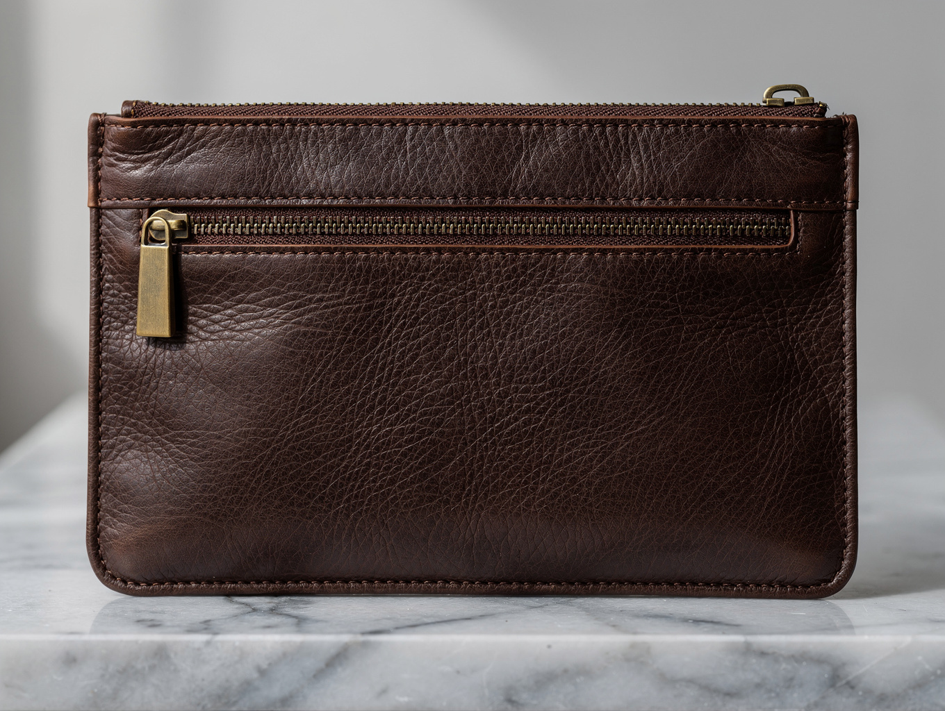 Macro detail of handcrafted full-grain leather handbag with saddle stitching and solid brass hardware