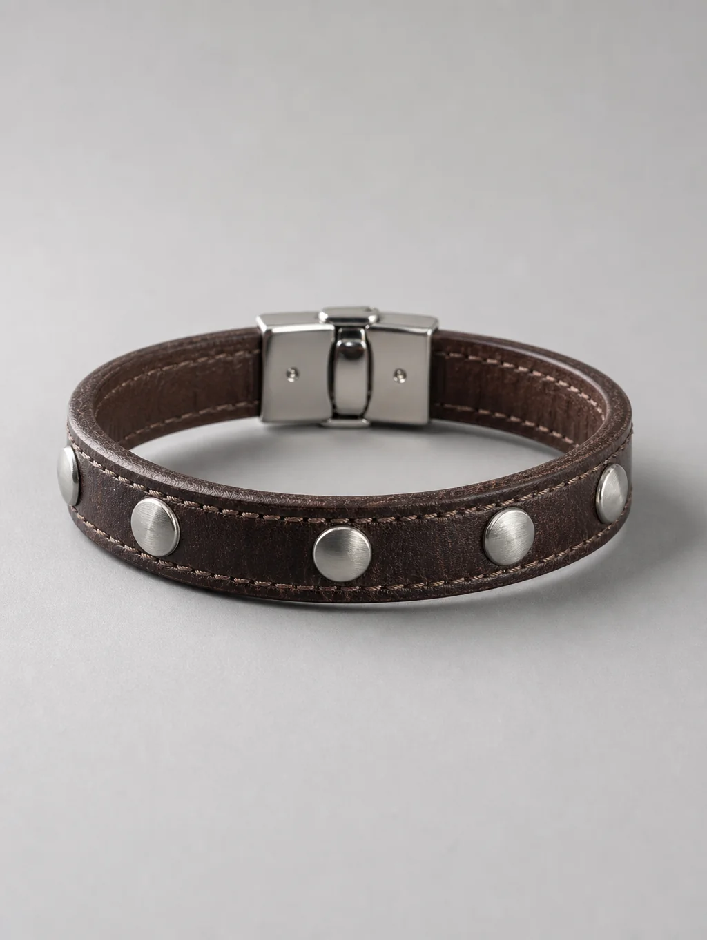 Hand-finished brass clasp accent fitted onto full-grain leather strap